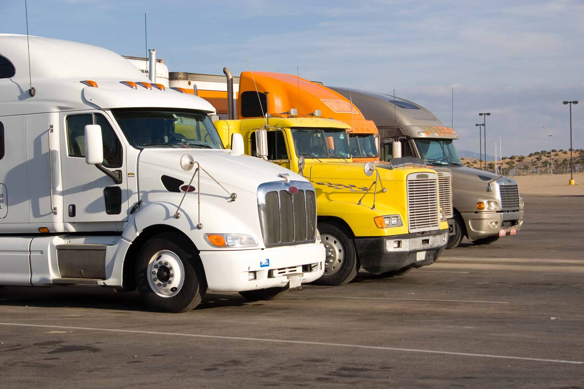 Four diesel trucks lined up in a row