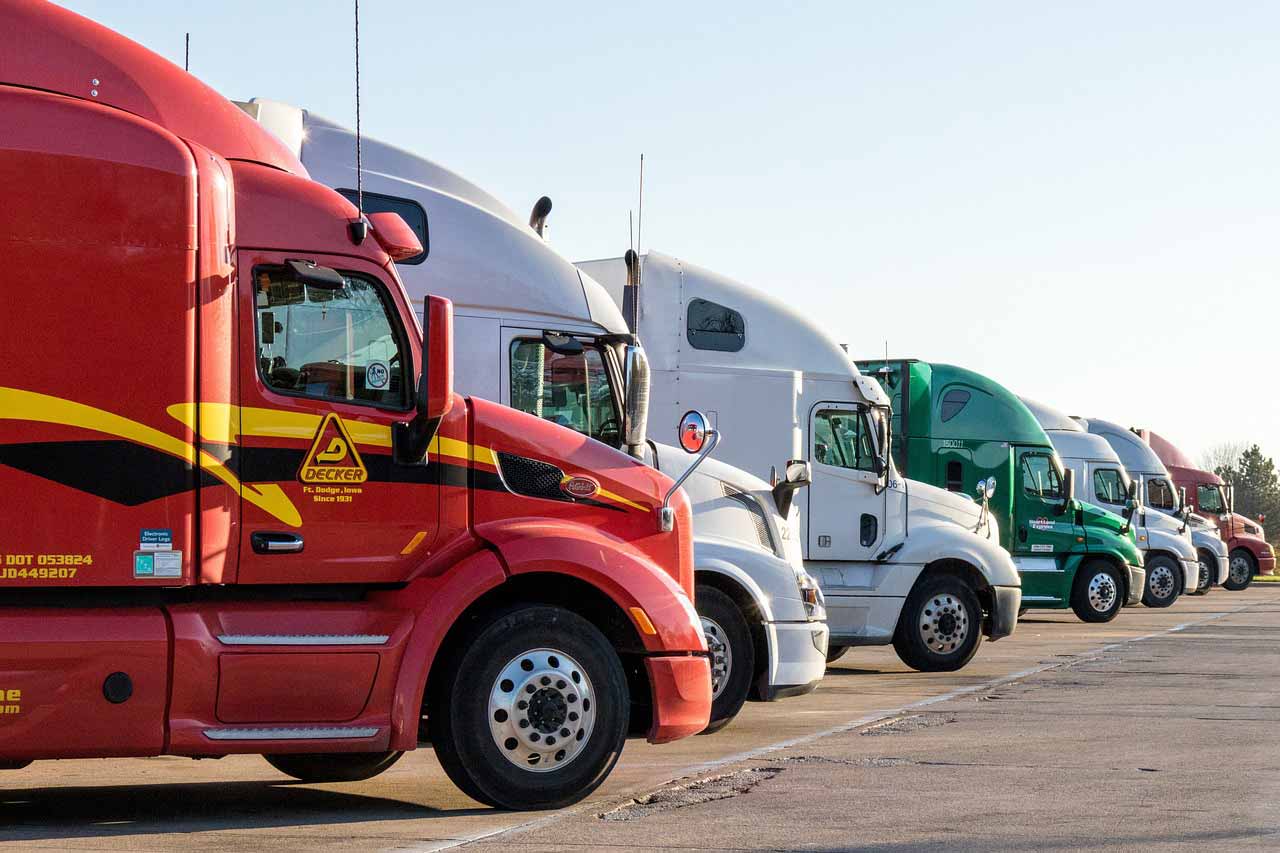 Many diesel trucks parked at a truck stop